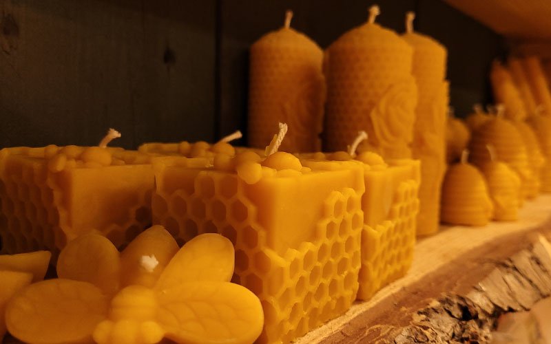 Gegoten bijenwaskaarsen die je bij de imker kunt kopen. Waskaarsen met honingraat en bijenmotief